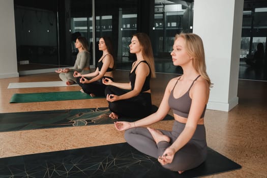 A group of beautiful girls are doing yoga in the fitness room. The concept of a healthy lifestyle.