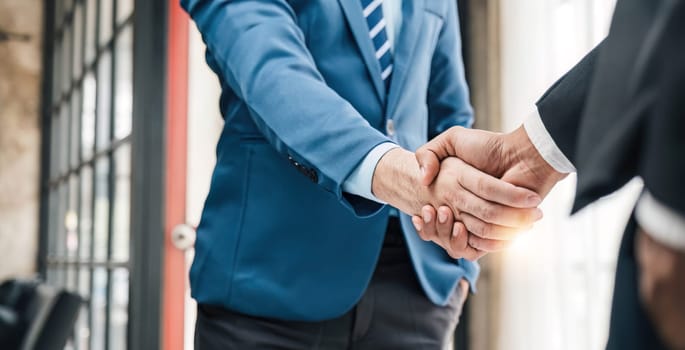 Business handshake for teamwork of business merger and acquisition,successful negotiate,hand shake,two businessman shake hand with partner to celebration partnership and business deal concept