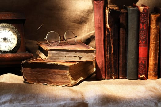 Nice vintage still life with old table clock and old books