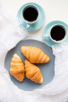 two cups of coffee with croissants on the background laces