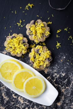 lemon cupcakes on a black background and a lemon on a plate