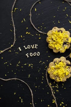 lemon cupcakes on a black background with lemon zest, inscription, I love food