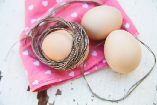 Top view of three eggs on rose napkin close up.