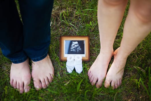 Husband and his pregnant wife , smiling and looking at the ultrasound pregnancy photo.