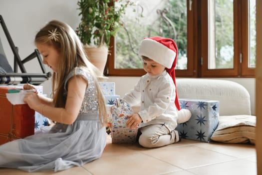 Brother and sister unwrapping christmas presents