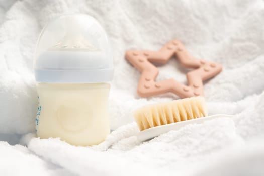 Several attributes of a newborn milk bottle toy and soft brush.