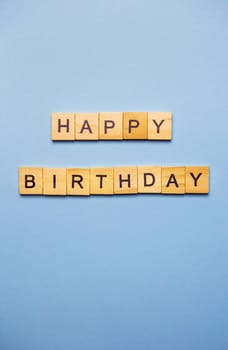 Happy birthday party, blue background with wooden text happy birthday. Ready postcard. Place for an inscription