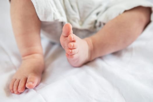 Small feet of a newborn baby. The concept of motherhood, breastfeeding