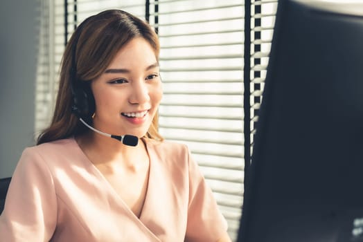 Competent female operator working on computer and while talking with clients. Concept relevant to both call centers and customer service offices.