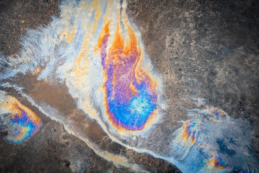 Gasoline oil spill on the pavement as a texture or background. Environmental pollution concept