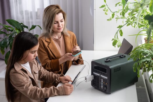 mother and daughter use a portable charging station.