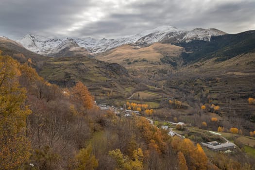 Snowy mountains under cloudy sky landscape in Boi Valley in Pyrenees in Catalonia