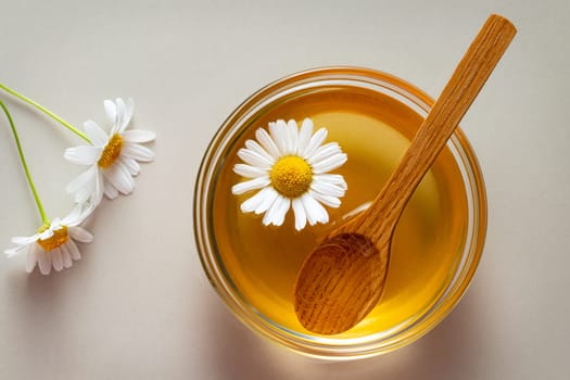 Chamomile syrup in a small bowl and jar on the kitchen table.