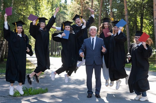 A university professor and seven robed graduates are jumping outdoors