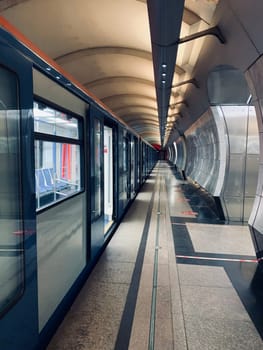 An empty underground metro station after a working day. The doors of the cars are open for passengers.