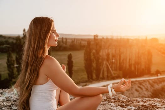 Young woman with black hair, fitness instructor in pink sports leggings and tops, doing pilates on yoga mat with magic pilates ring by the sea on the beach. Female fitness daily yoga concept