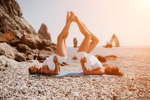 Woman sea yoga. Back view of free calm happy satisfied woman with long hair standing on top rock with yoga position against of sky by the sea. Healthy lifestyle outdoors in nature, fitness concept.