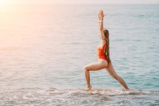 Woman sea yoga. Back view of free calm happy satisfied woman with long hair standing on top rock with yoga position against of sky by the sea. Healthy lifestyle outdoors in nature, fitness concept.