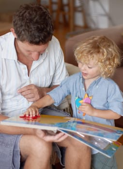 Man with boy child, reading book for education and development, spending quality time together at home. Family, teaching and learning with father and kid bonding, picture story with toys for growth.