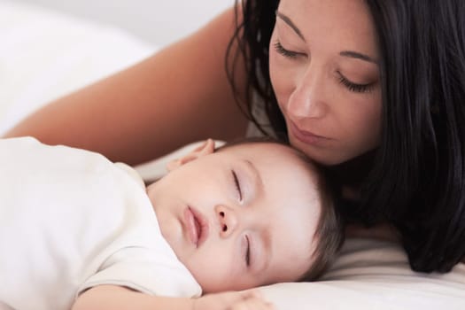 Baby, sleeping and mother in a home bedroom with parent support, care and love. Relax, bed and young girl with mom in a house feeling tired and sleepy with mama rest looking at fatigue of kid.