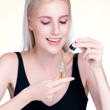 Personable closeup woman with natural makeup applying essential serum oil bottle for skincare product. CBD oil dropper pipette for cosmetology treatment and cannabinoids concept in isolated background