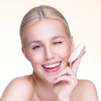 Closeup personable beautiful natural soft makeup woman using powder puff for facial makeup concept. Cushion foundation applying on young girl face in isolated background.