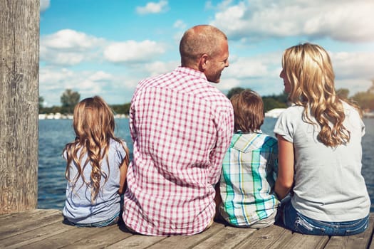 Family over everything. a family on a pier while out by the lake