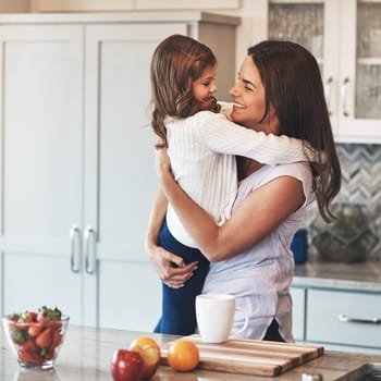 Youre the apple of my eye. a happy mother hugging her cute little girl in the kitchen at home