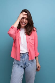 shy brunette woman with dark hair below her shoulders posing against a studio background.