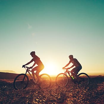 They never stop moving. a pair of adventurous mountain bikers out on a trail on a sunny day