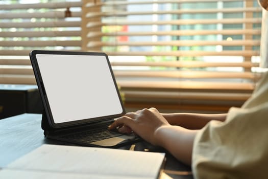 Close up view of woman hands typing on keyboard, studying online classes on digital tablet. Online learning, homeschooling concept.