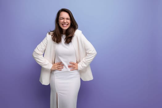 happy lucky brunette woman in ivory jacket and white dress on purple background with copy space.