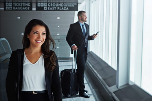 When we travel, we travel in style. two executive businesspeople walking through an airport during a business trip