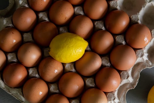 Chicken eggs lie in a tray on a kitchen surface with a yellow lemon. Buying products and goods in the store