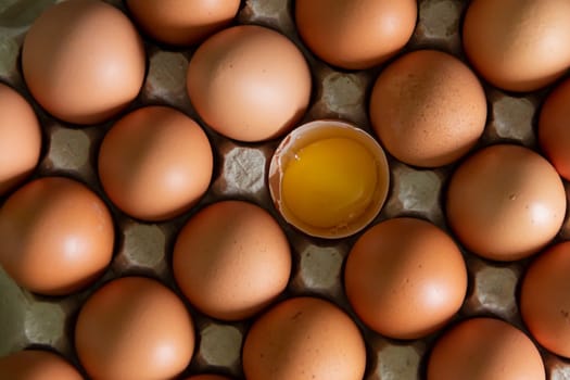 Chicken eggs lie in a tray on the kitchen surface with a broken yellow yolk. Buying products and goods in the store