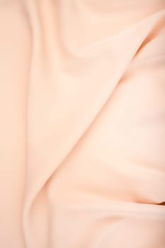 Texture of the satin fabric of beige color for the background