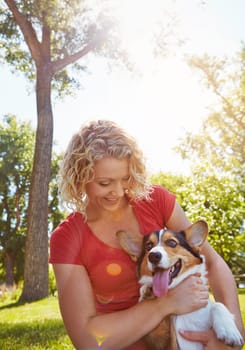 The best treat you can give your dog is love. a young woman bonding with her dog in the park