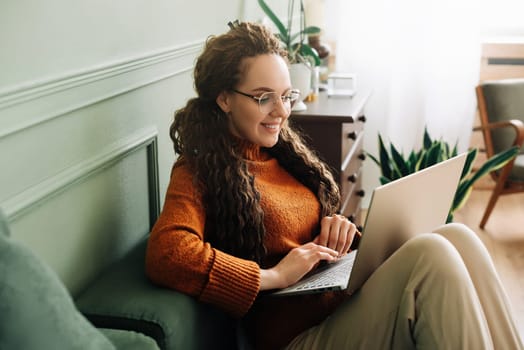 Relaxed Young woman on sofa surfing the internet, shopping and learning. Online shopping, learning and entertainment with a relaxed woman at home