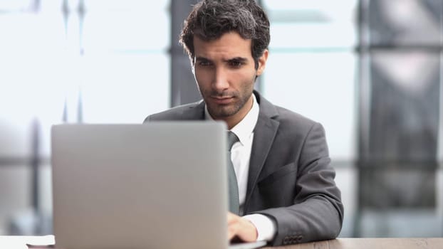 Successful businessman working inside office, man in business suit working at workplace with documents and laptop