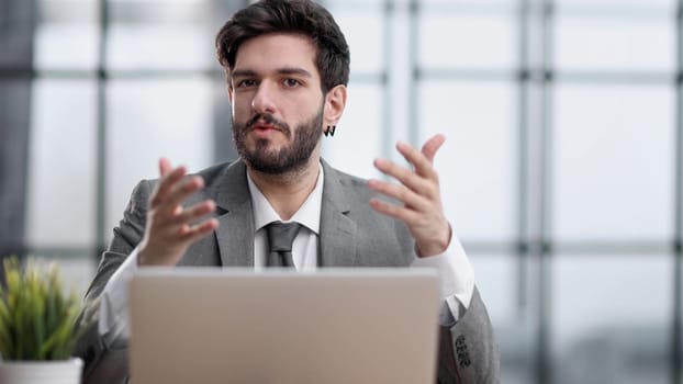 Pensive businessman sitting at the table with laptop