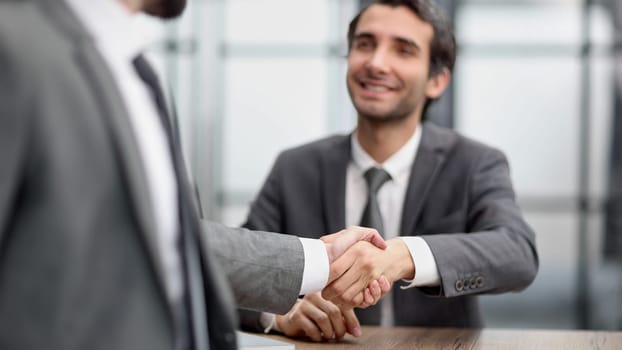business man greets the employee with a handshake,