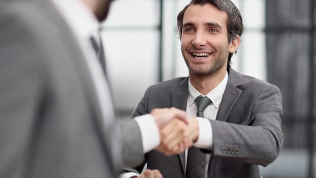 business man greets the employee with a handshake,