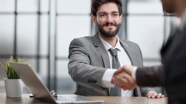 Portrait of cheerful young manager handshake with new employee.