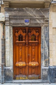 Vintage wooden swing door with carving, in marble veneer