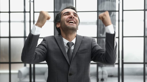 businessman with arms up celebrating his victory