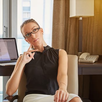 In a thoughtful mood...A young businesswoman looking thoughtful while sitting in her hotel room