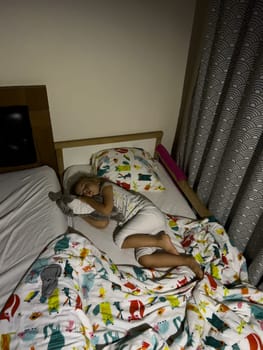 Little girl sleeping on a baby bed hugging a plush toy. High quality photo