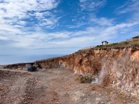 Drilling rigs work in a quarry against a cloudy sky. High quality photo