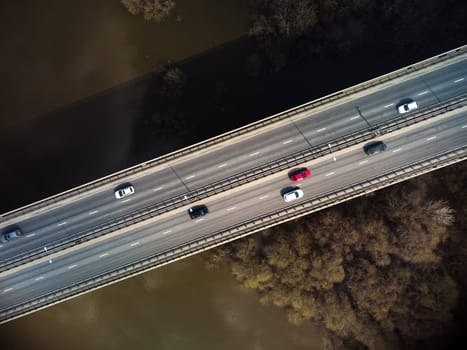 A road bridge over the river, taken from a quadrocopter. Urban traffic.