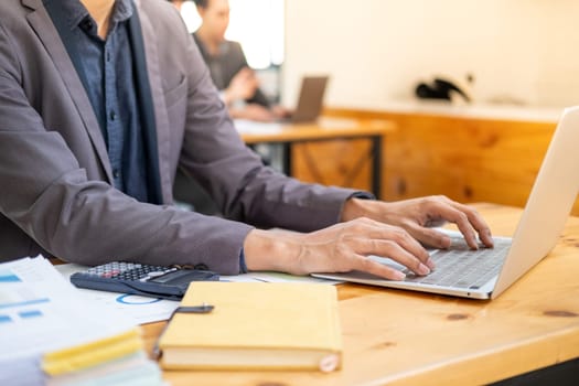 Closed up young smart businessman officer employee working typing on laptop computer. High quality photo